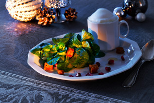 Maroni-Lebkuchen-Capucino angerichtet auf einem Teller mit Feldsalat