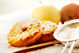 2 Apfelküchle mit Apfel im Hintergrund