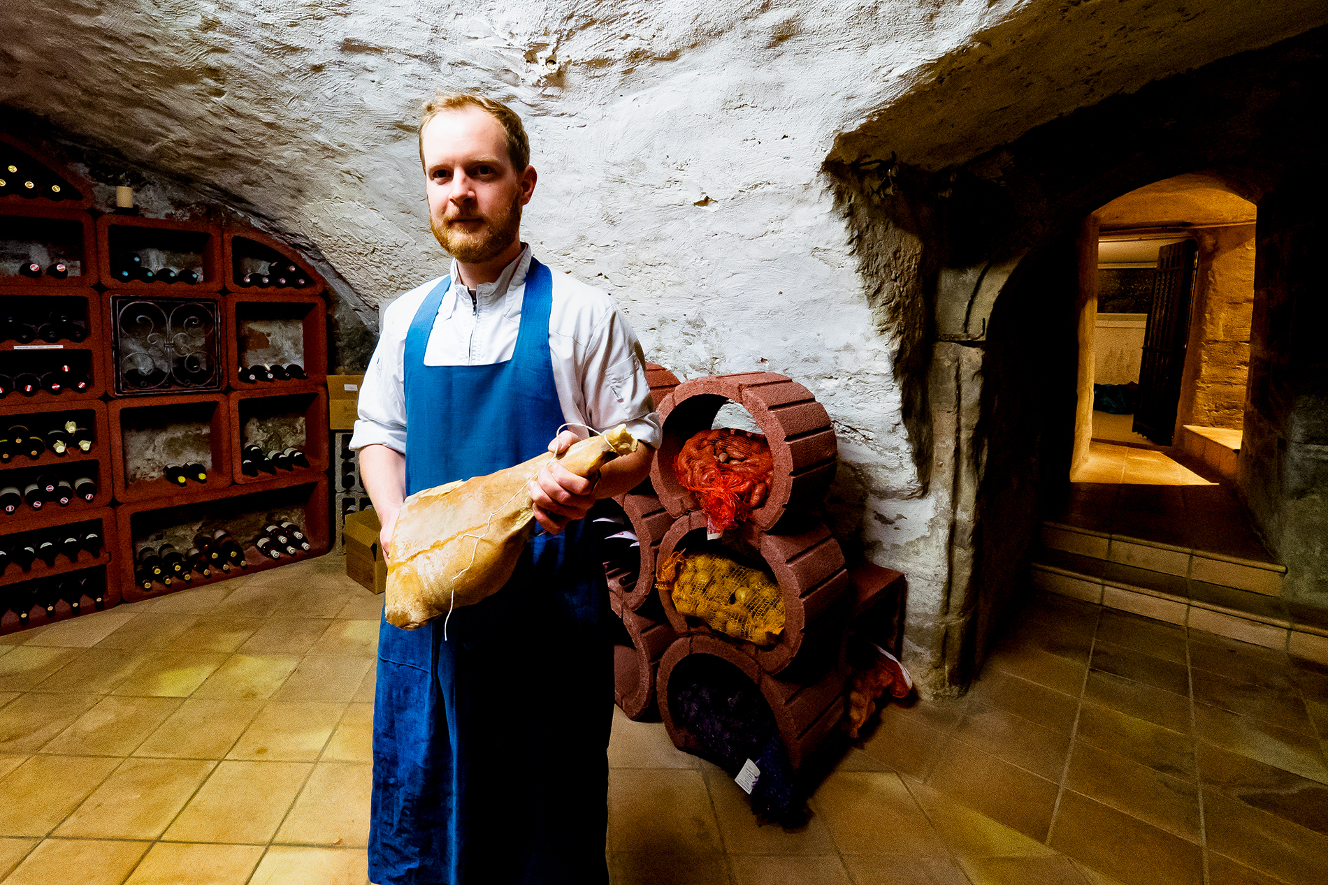 Felix Schneider mit Schinken im Gewölbe des Restaurant Sosein